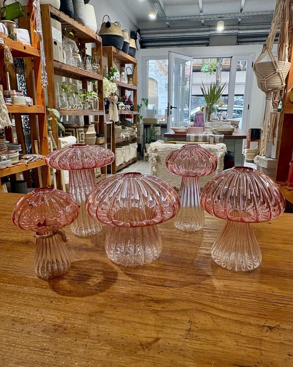 Lámparas hongo de vidrio rosa sobre la mesa de madera